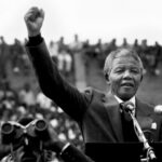 nelson-mandela-discurso-publico-brazo-en-alto-daniel-colombo-1-e1651106082893